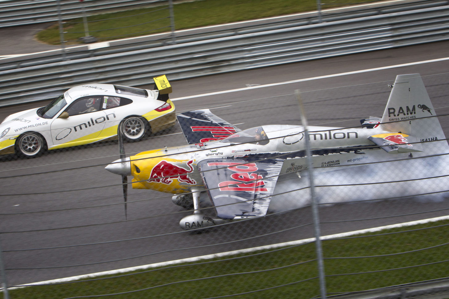 Flugzeug gegen Auto: Hannes Arch in der Zivko Edge 451 HA Rennmaschine und DTM Piloten Hubert Haupt im Porsche GT3