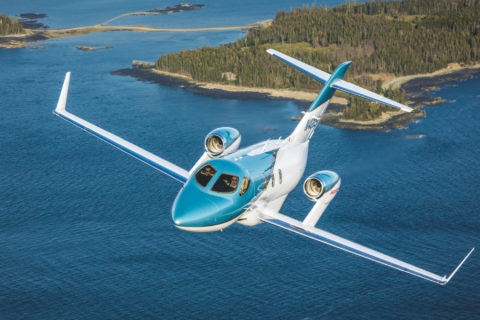 HondaJet Elite 2 im Flug vor malerischer Landschaft.