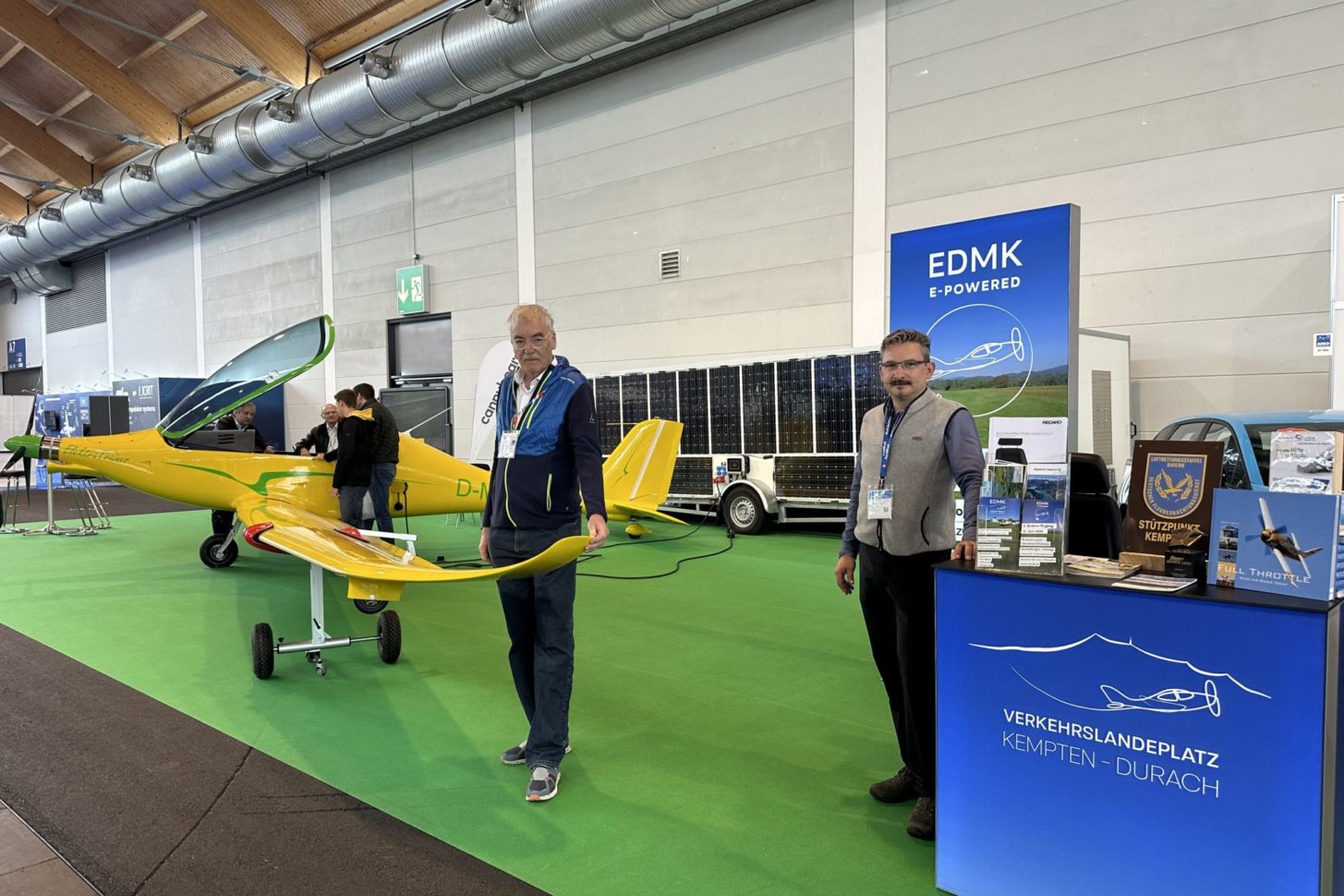 Calin Gologan, CEO von Elektra Solar, neben dem neuen Elektra Trainer auf der AERO 2024, ausgestattet mit innovativen Winglets und Solar-Anhänger für nachhaltige Flugabenteuer. Rechts: Konstantin Hadrossek vom Flughafen Kempten-Durach mit der ersten öffentlichen Ladestation für Flugzeuge.