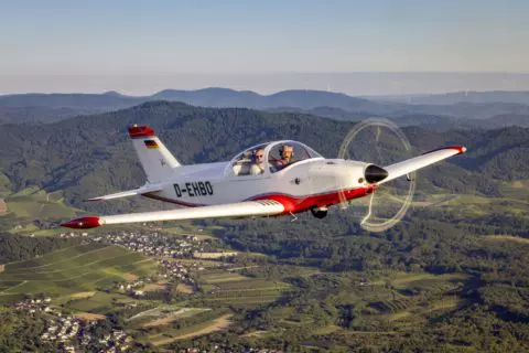 Wendiges Reisegerät: Der Holztiefdecker mit Einziehfahrwerk fliegt äußerst agil. Erbauer Heribert Orlik sitzt im Bild im linken Pilotensitz.